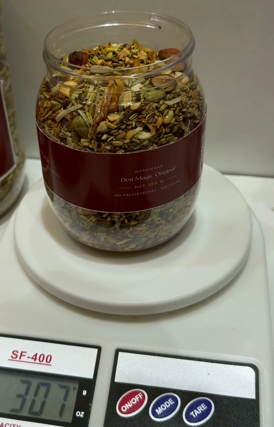 A filled Desi Magic jar on a kitchen scale reading 307 g